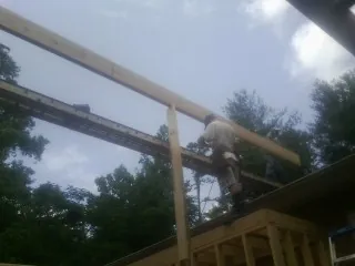Carpenter setting a ridge beam over a new addition frame — Ice Dam Removal by Roofing Brothers in Florissant