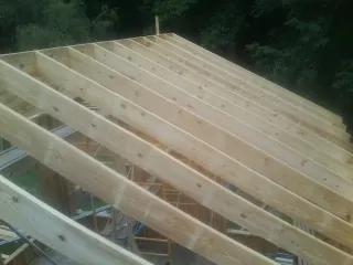 New roof rafters set over an addition before sheathing in Florissant