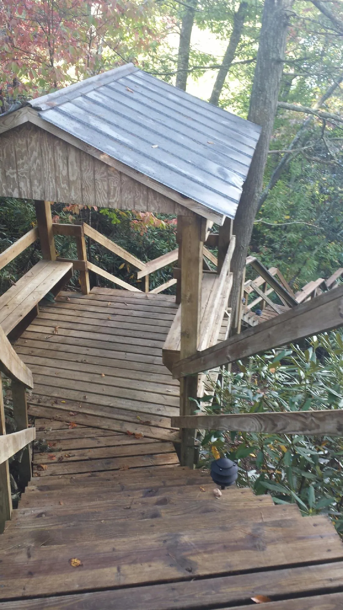 Metal roofed shelter over wooden steps on a wooded walkway — Skylight Repair & Installation work by our crew in Florissant