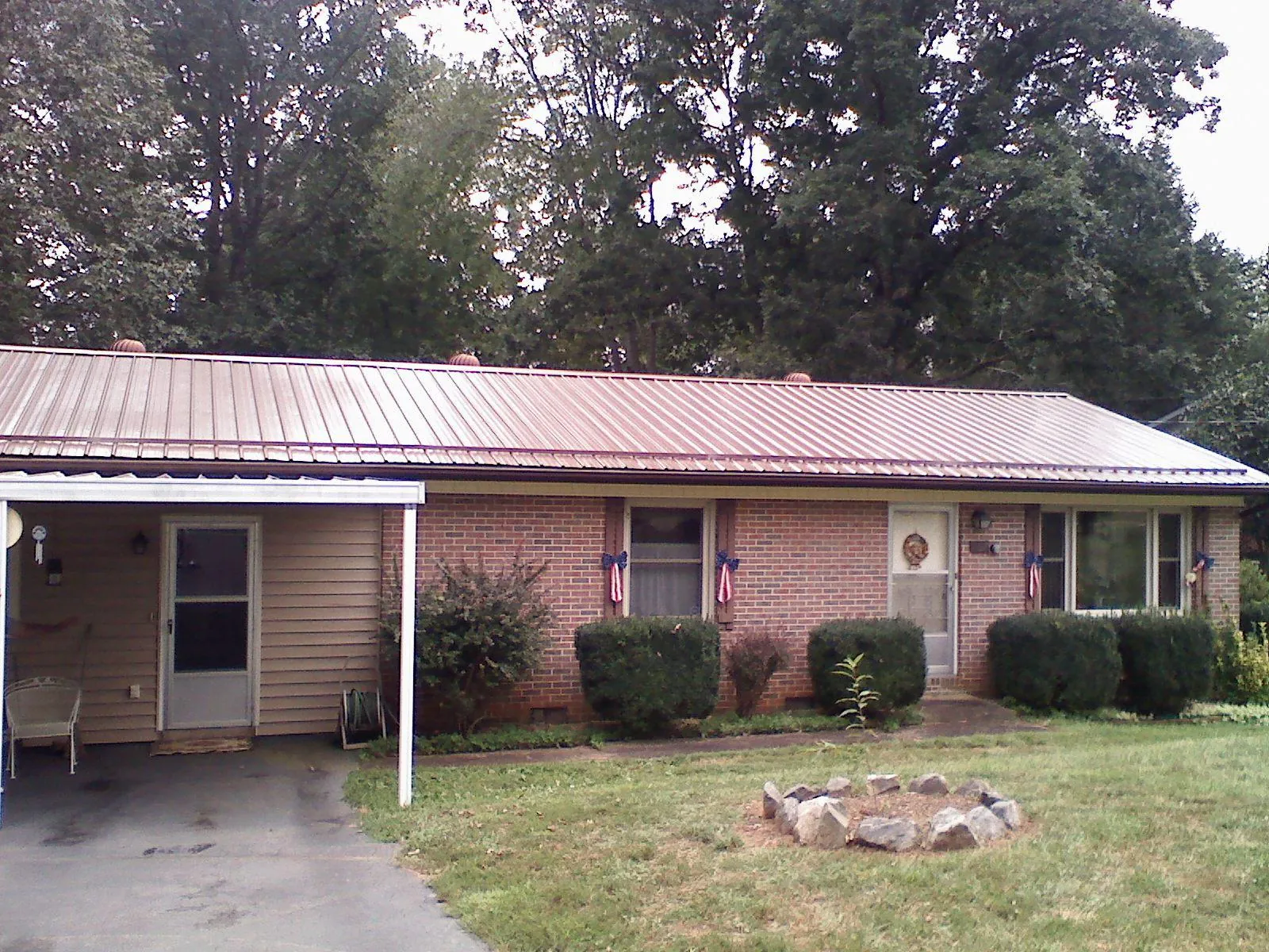 Bronze metal roof and carport on a brick ranch home — Roof Repair work by our crew in Florissant
